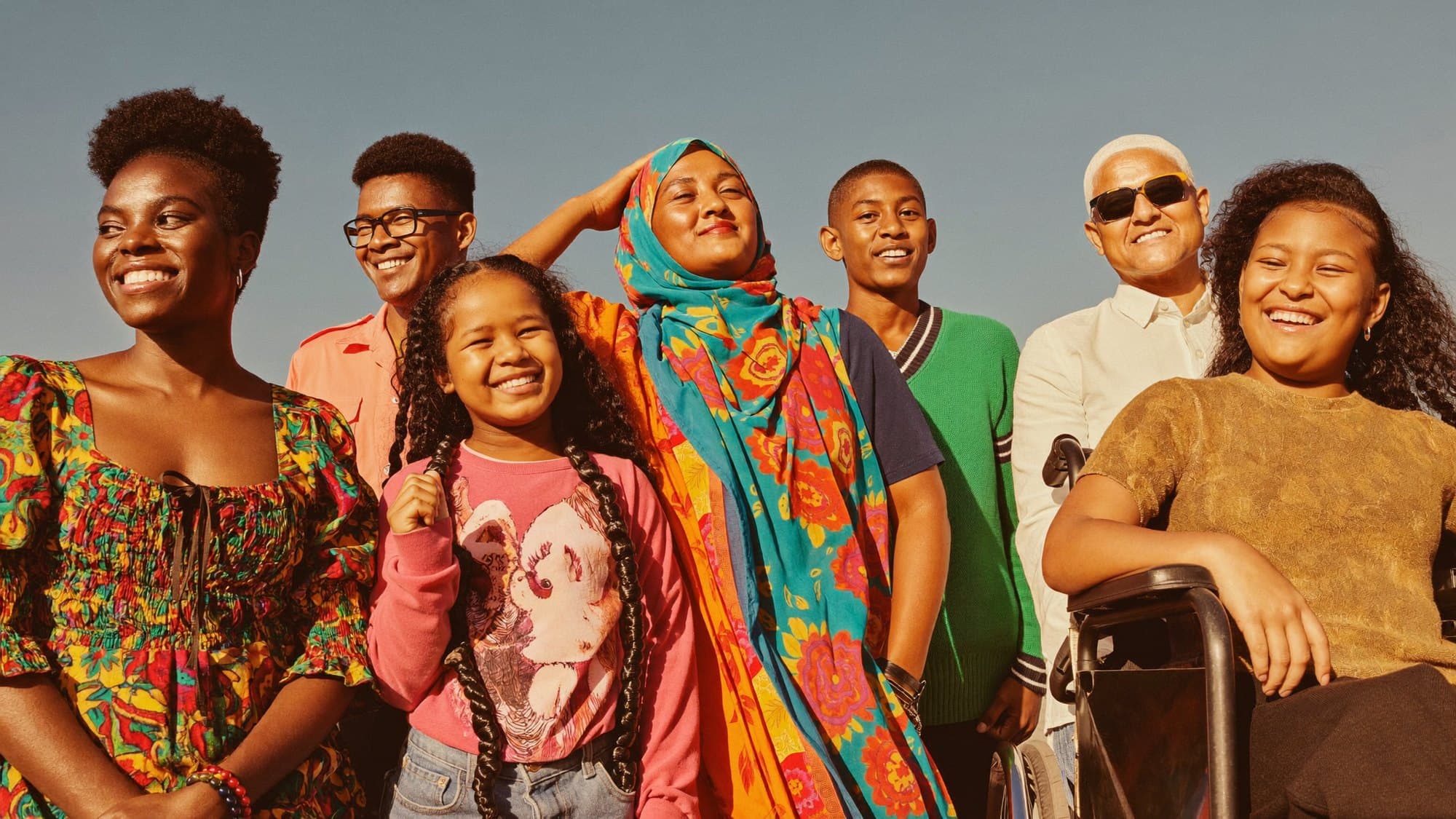 A joyful, diverse global community standing together in bright daylight